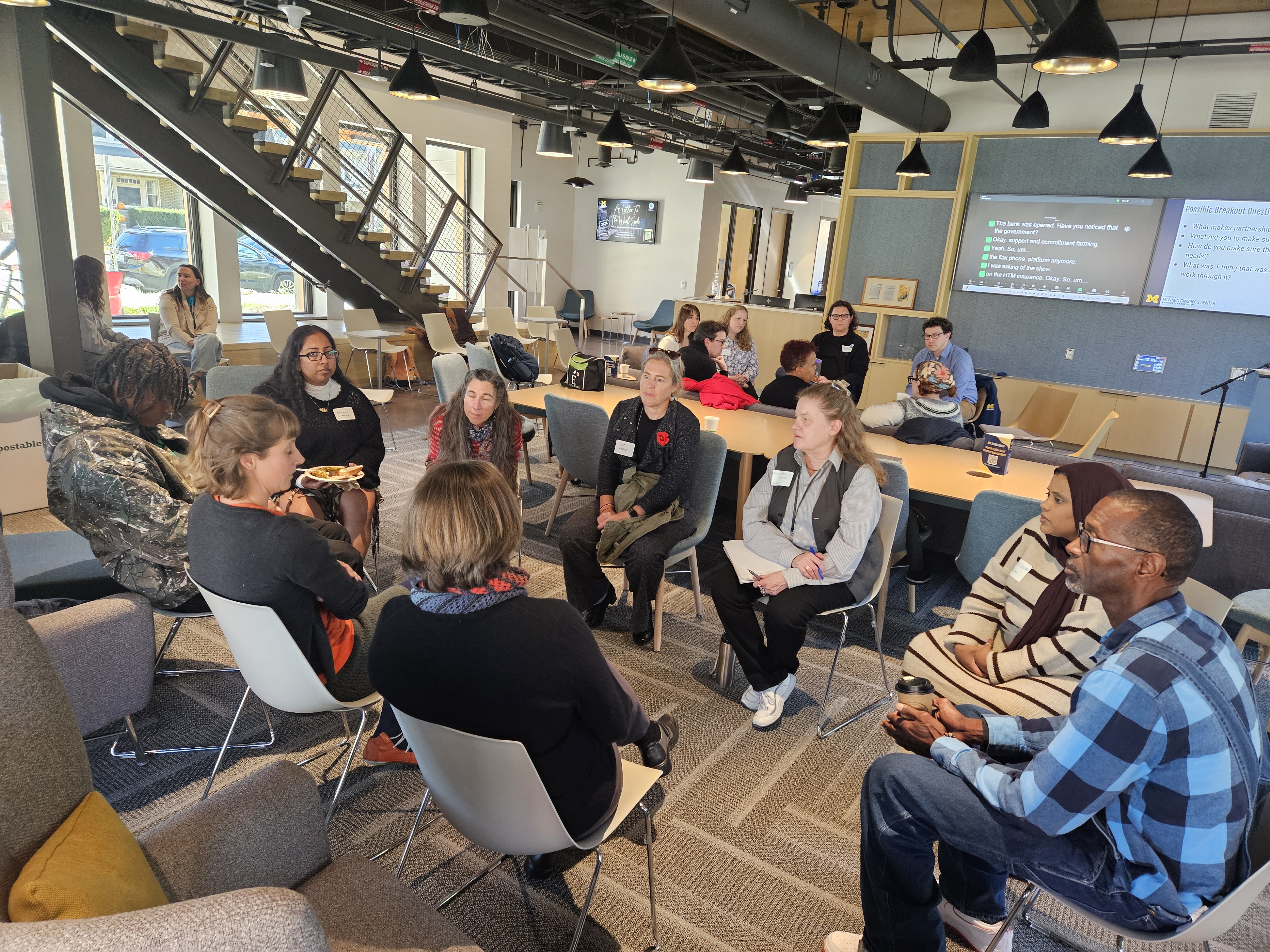 two groups of people seated in circles talking together in the Community Commons