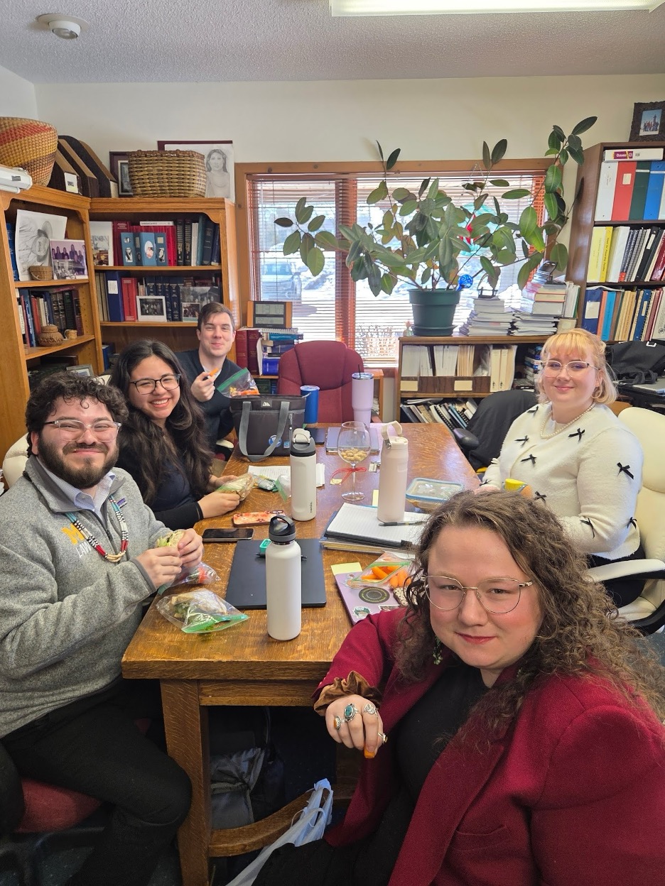 A group of 5 students working at a table