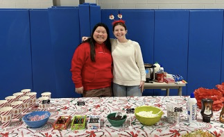 two people standing in front of a table with snacks