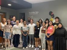 Group of 14 students and one Ginsberg staff member smiling.