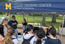 A group of students standing near a blue Ginsberg Center tent.