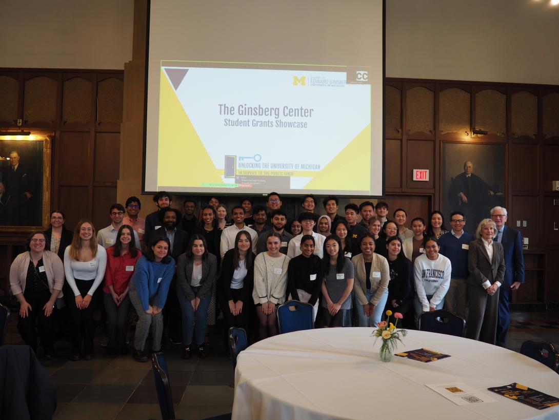 Group photo at the Student Grants Showcase with Powerpoint Slides in the background