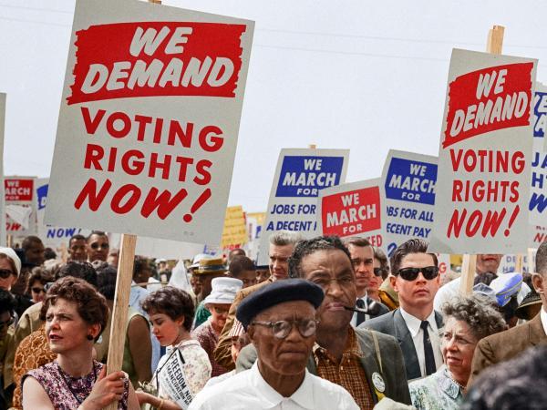 group of people holding signs saying We Demand Voting Rights Now