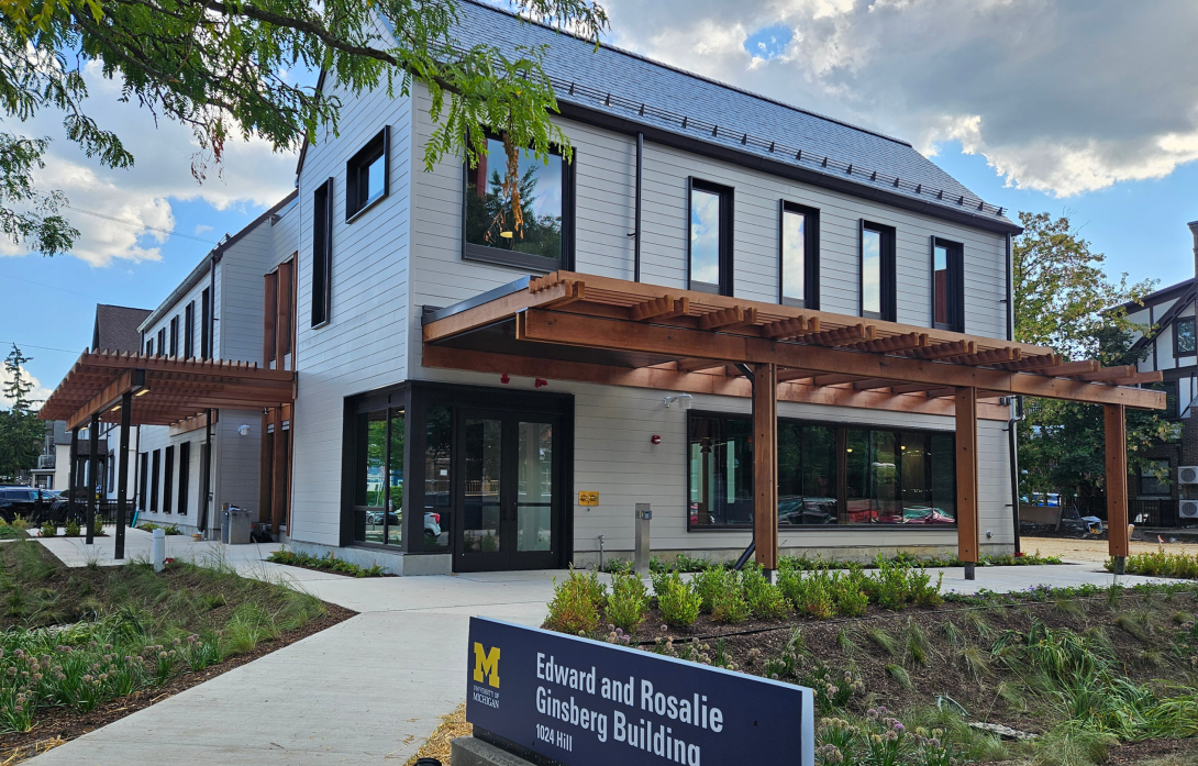The Edward & Rosalie Ginsberg Building, a 2 story building with many windows and wood portico on the corner of E University and Hill St