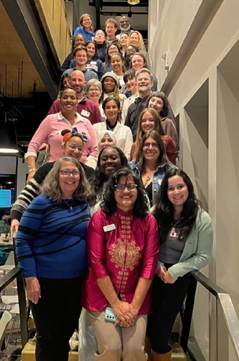 30 smiling people lined up in rows on a staircase 