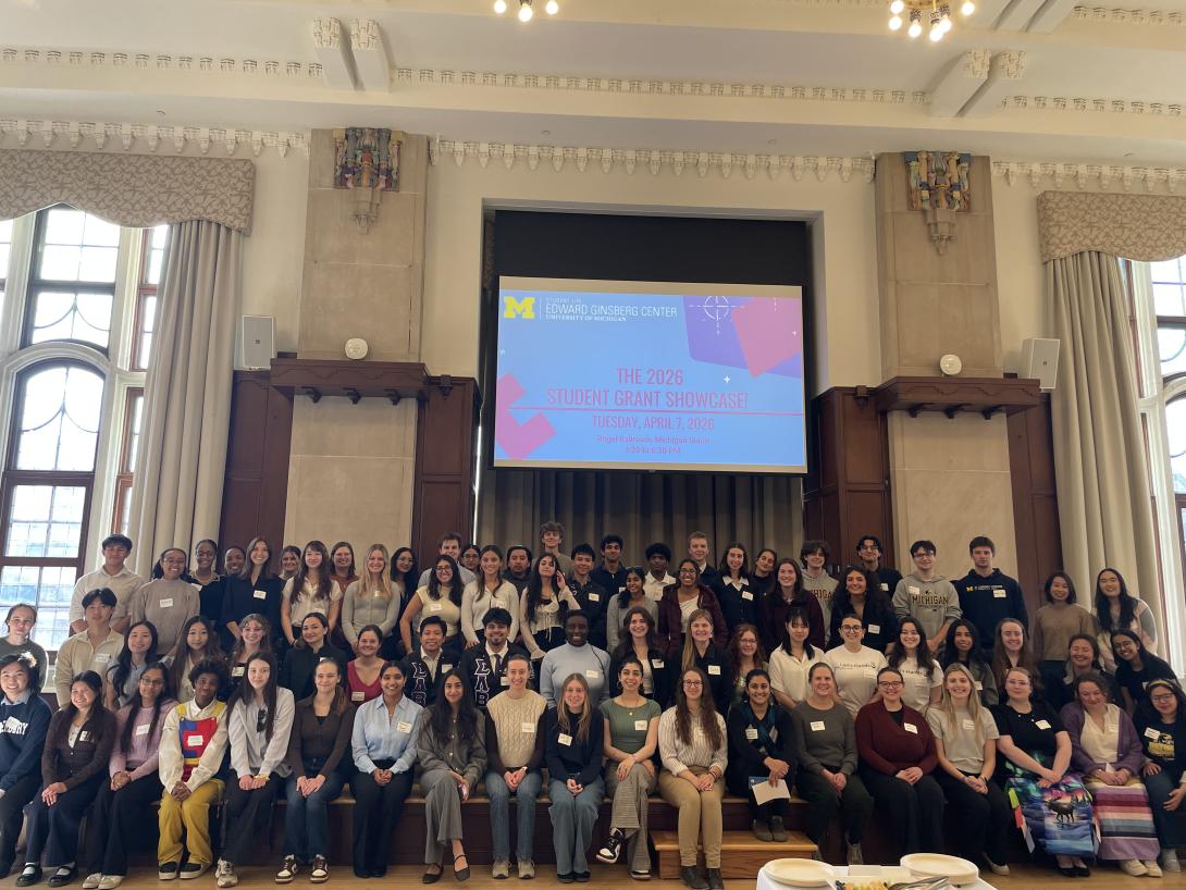 Group photo at the Student Grants Showcase with Powerpoint Slides in the background